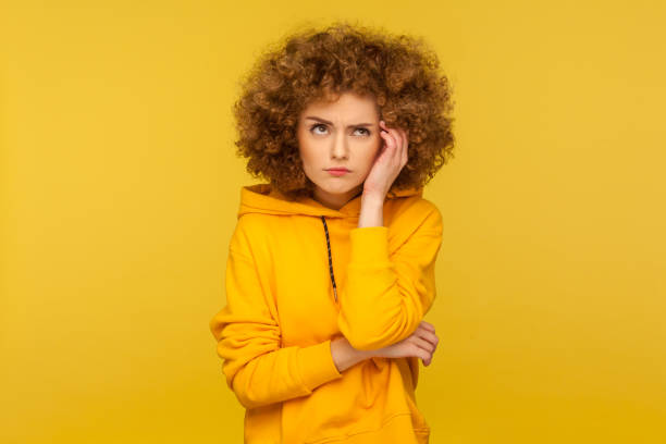 hmm, need to think! portrait of confused pensive curly-haired woman in urban style hoodie having doubts - pensive question mark teenager adversity imagens e fotografias de stock