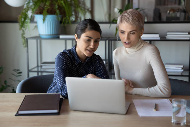 istock Multiethnic women working together using laptop discussing new app 1256907157