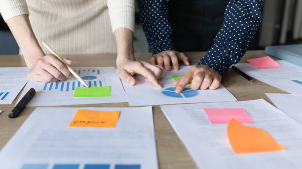 istock Two businesswomen analyzing project stats reviewing data on charts closeup 1256907171