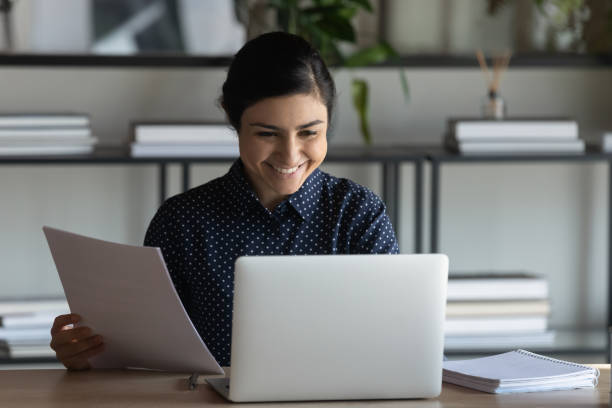 istock Indian female employee use pc accomplish paperwork feels satisfied 1256907187