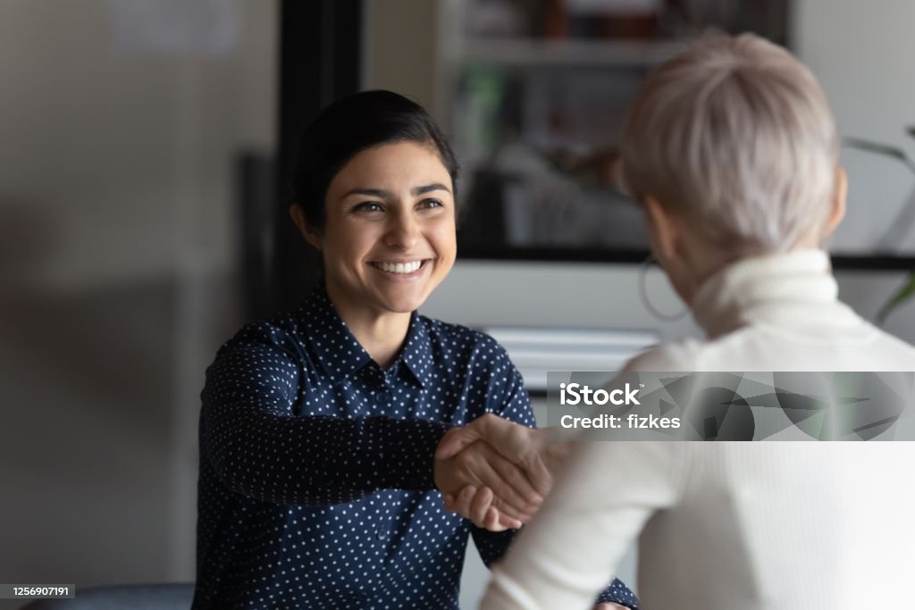 Successful manager making deal with partner shake hands express respect Happy employer HR manager shaking hands with indian job seeker welcoming vacancy applicant. Successful manager making deal with partner, good positive first impression, start business meeting concept Customer Stock Photo