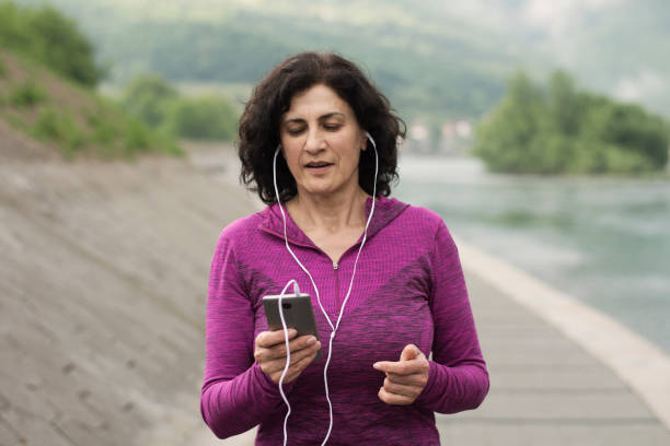 istock Mature female jogger using phone 1256909698