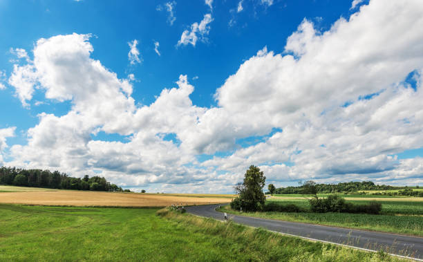 Impressive sky with cumulus clouds over a rural landscape Impressive sky with cumulus clouds over a rural landscape with an asphalt road.
Germany, Hessen near Kirtorf horizon over land stock pictures, royalty-free photos & images