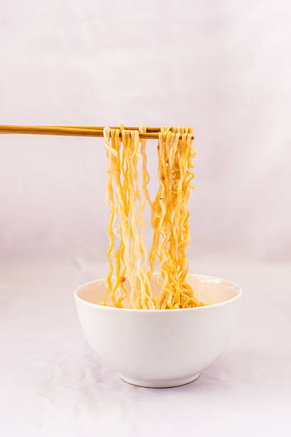 istock Chopsticks holding noodles on a white bowl 1256914059