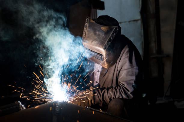 istock Closeup worker in a mask doing the welding in a workshop 1256915191