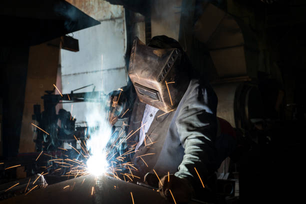 istock Closeup worker in a mask doing the welding in a workshop 1256915192