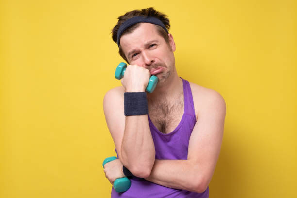 istock Sad man with a dumbbell being tired after training. 1256916815