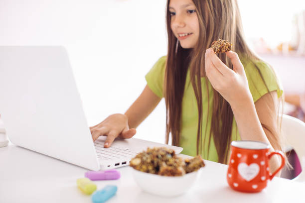 istock Girl studying and doing homework on laptop at home 1256917770