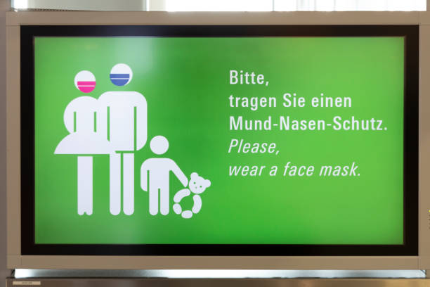 コロナが閉鎖するので、フランクフルト空港で看板はマスクを着用 - frankfurt international airport ストックフォトと画像