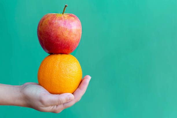 apple and orange. healthy fruit. - apple orange comparison individuality imagens e fotografias de stock