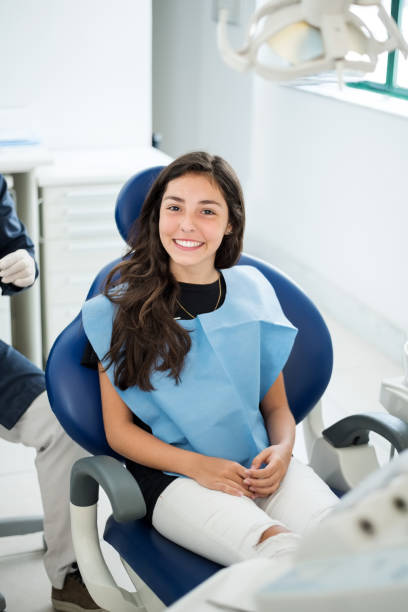 посещение стоматолога для регулярного осмотра - smiling dentist office dentists chair women стоковые фото и изображения