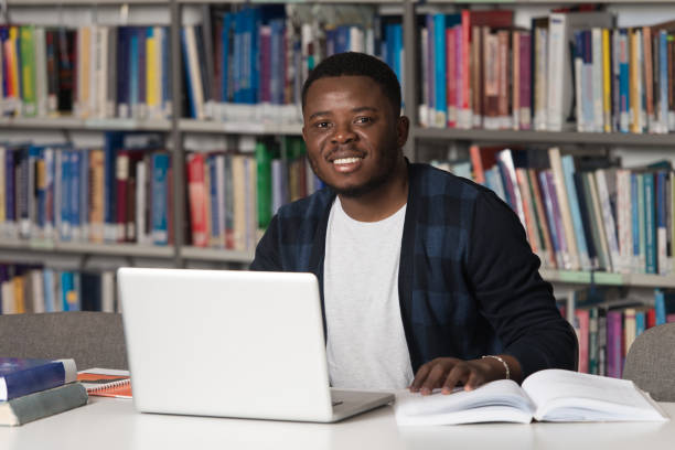 istock Happy African Male Student With Laptop In Library 1256931017