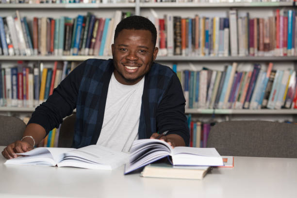 istock Happy African Male Student With Laptop In Library 1256931023