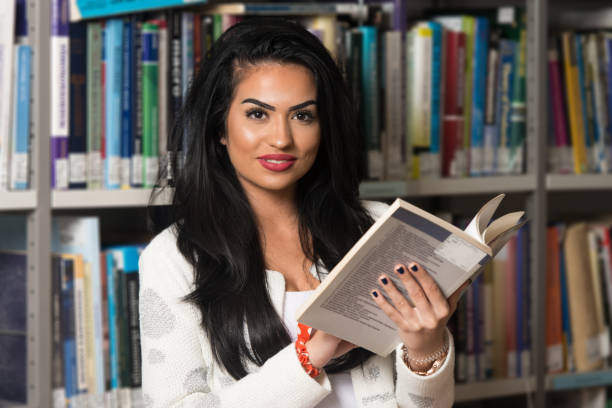 istock Happy Female Student With Book In Library 1256931049
