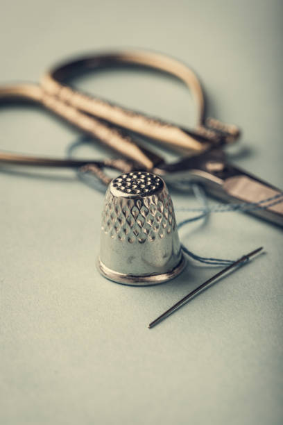 vintage silver thimble on blue - thimble sewing item close up studio shot imagens e fotografias de stock