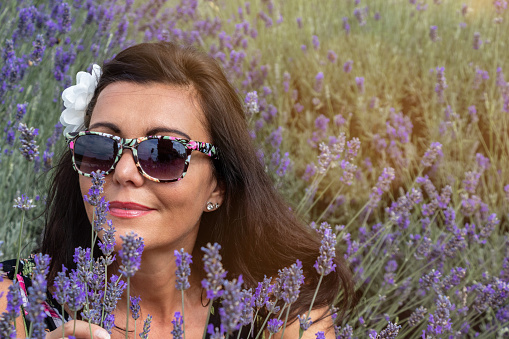 Close-up of mature woman enjoying in lavender field