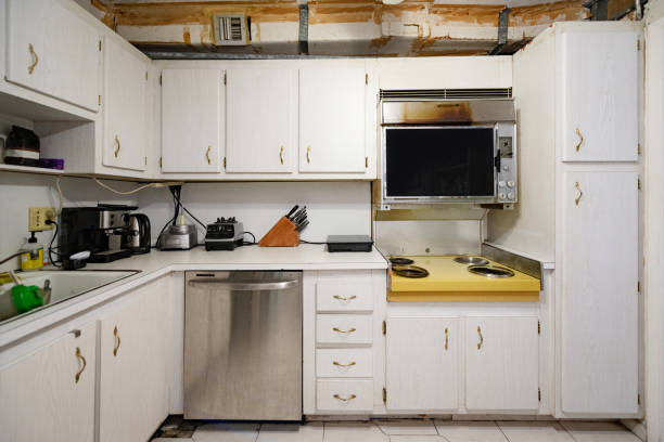 Out Dated Kitchen Interior Before Home Renovation in Florida USA This photograph is of a kitchen interior with a stovetop and cabinets from 1969 before home renovation in Florida, USA. small florida home stock pictures, royalty-free photos & images