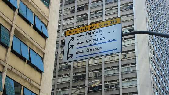 Rio de Janeiro, Brazil: close up of a street sign, with the windows of office towers in the background. Taken in a street of Downtown Rio