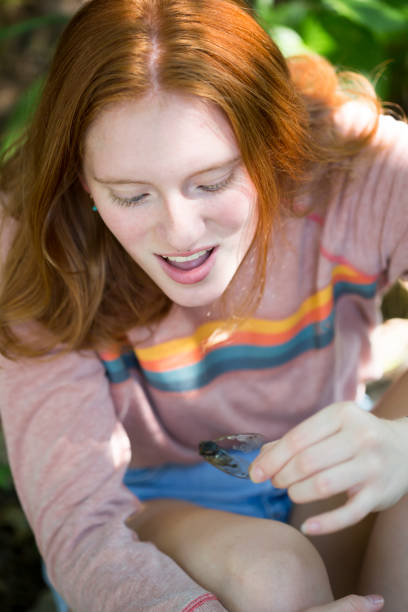 istock Redheaded teen holds cicada 1256941710