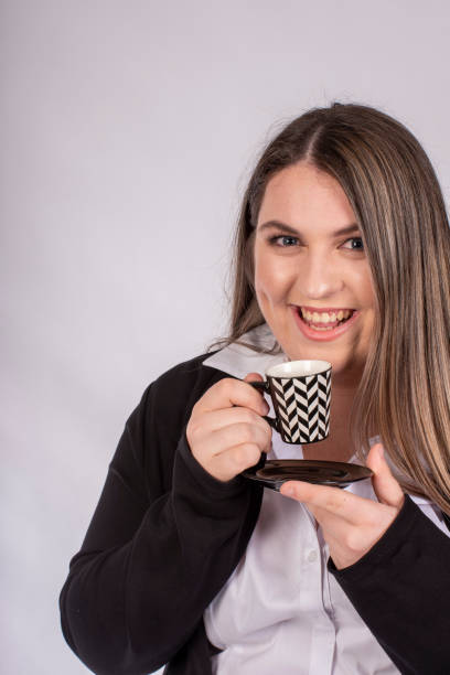 笑顔の若い女性はデミタッセでコーヒーを楽しんでいます - 7649 ストックフォトと画像