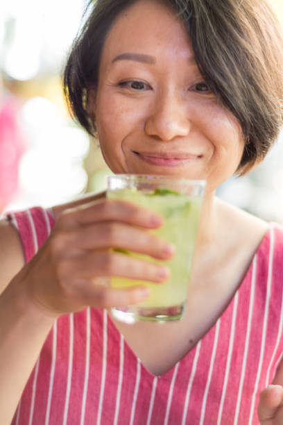 signora asiatica degustazione caipirinha a copacabana rio de janeiro - thai cuisine asian cuisine vertical close up foto e immagini stock