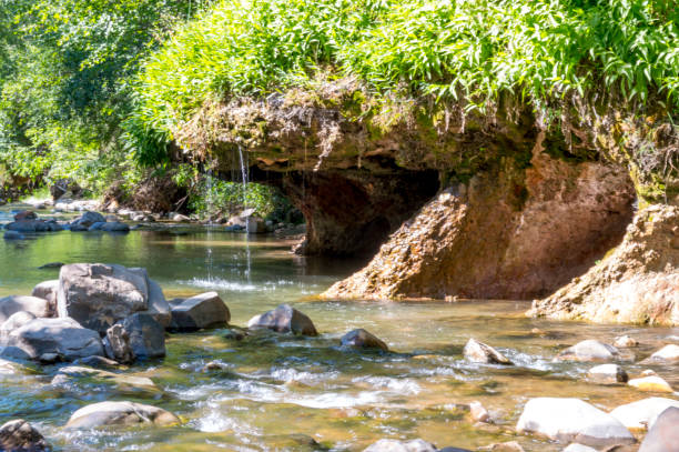 Dripping Rock Falls/Hike on a Summer Afternoon This shows the Dripping Rock Hike in Spanish Fork, Utah. Along the river are small caves or grottos surrounded by streams of water dripping down into the river.  This shot was taken on a hot summer afternoon. spanish fork utah stock pictures, royalty-free photos & images