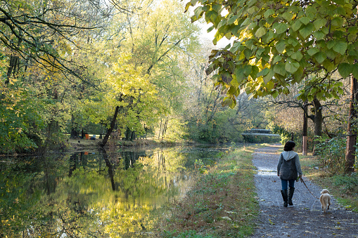 Woman walking with her dog along the river canal