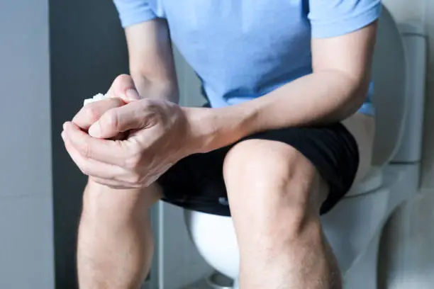 Man's hand, he holds a roll of toilet paper Going to the bathroom Toilet toilet background