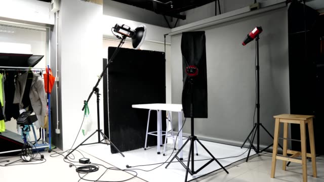 Photographer set up studio room with lighting equipment background in timelapse