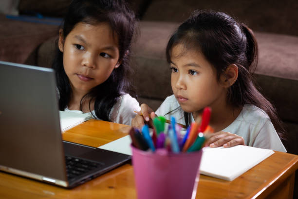 istock Two asian child girls using notebook to learning online technology together. 1256957945
