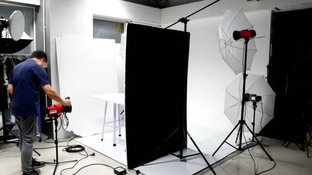 Photographer set up studio room with lighting equipment background in timelapse