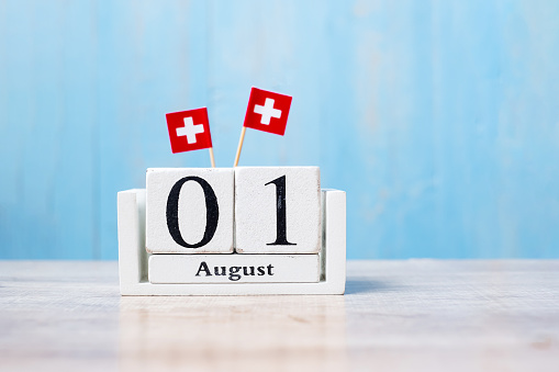 Wooden calendar of August 1st with miniature Switzerland flags. Swiss National Day and happy celebration concepts