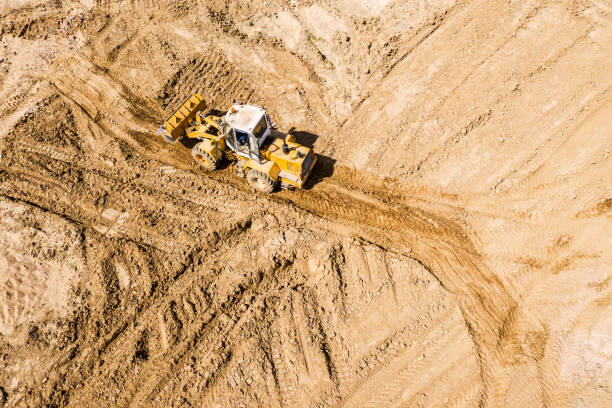 istock yellow earthmover adjust elevation level soil for construction site. aerial view 1256962228