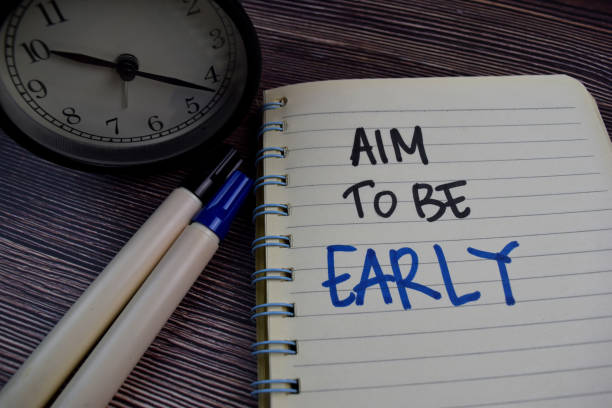istock Aim To Be Early write on a book isolated on the table. 1256967340