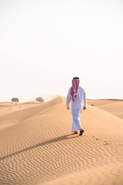 istock arabic man walking in the desert 1256967658