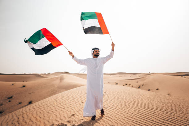 istock man with uae flag in the desert 1256967908