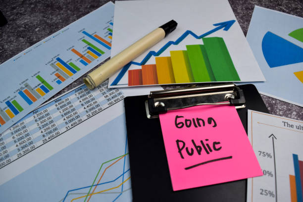 istock Going Public write on sticky notes isolated on Office Desk. Stock market concept 1256967943