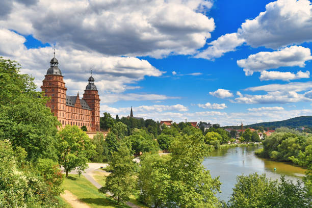 Aschaffenburg, June 2020: Beautiful view over German city Aschaffenburg with Main river, palace called 'Schloss Johannisburg' and green park on sunny summer day