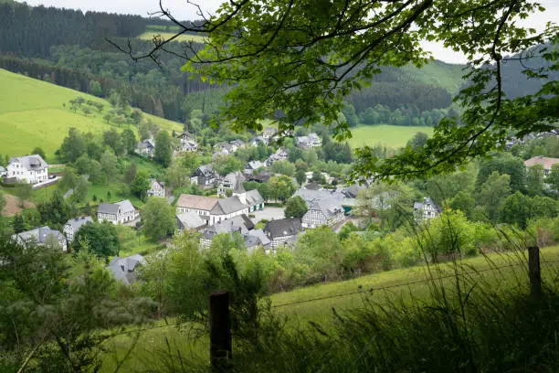 Panoramic image of a small village close to Winterberg with meadows, hills and trees, Sauerland region, Germany