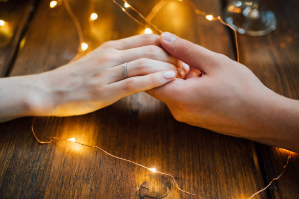 istock arms. loving couple sitting at table and holding hands. 1256977021