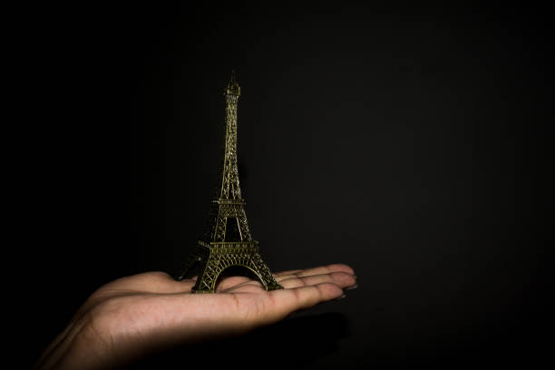 istock Miniature of Eiffel tower placed on a palm in a black background, design concept can be used in blogs,wallpaper designs 1256977697
