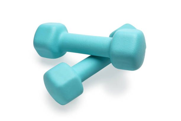 istock Two turquoise colored rubber dumbbells lying at white table 1256977969