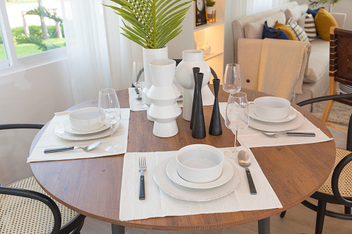 White dinnerware and table runners at the dining room of a family home.