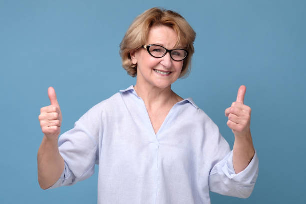 istock Caucasian elderly woman holding her thumb up 1256985385