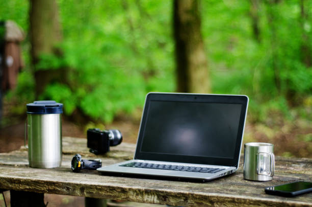 istock Computer Coffee Mug and Telephone on black wood table. 1256986599