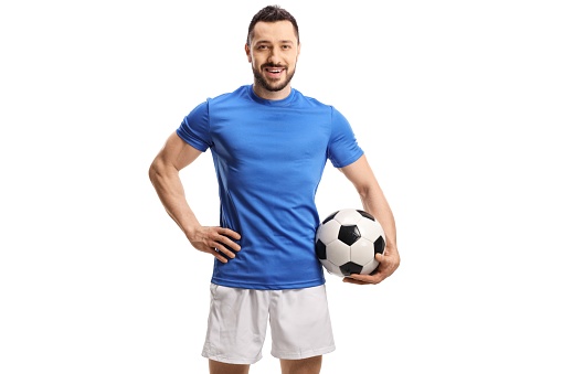 Soccer player in a blue jersey holding a football isolated on white background