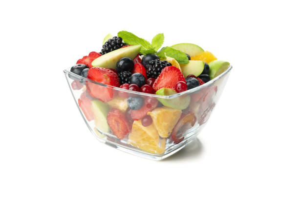 istock Bowl of fresh fruit salad isolated on white background 1256989078