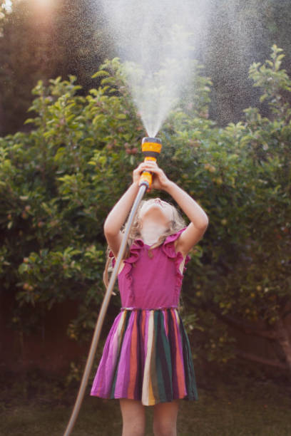istock Little Girl Playing with Hose 1256990192