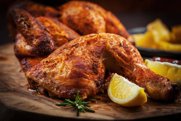 Spicy grilled chicken with lemon on wooden background