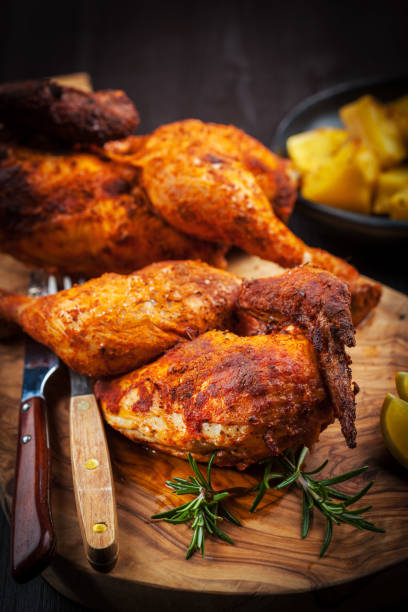 istock Spicy grilled chicken with lemon on wooden background 1256990469